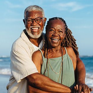 happy senior couple with ocean in the background
